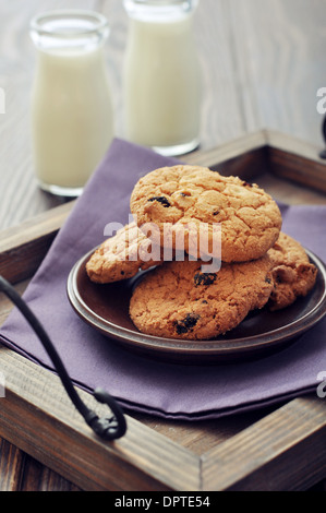 Chocolate chip cookies with milk in bottles on wooden tray Stock Photo