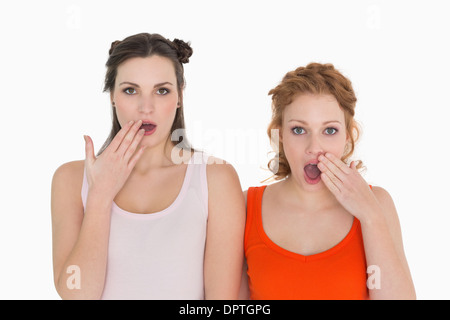Shocked female friends with hand over mouth Stock Photo