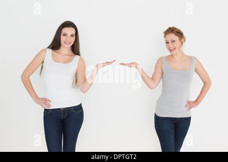 Two happy young female friends holding out their hands Stock Photo
