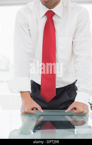 Mid section of a well dressed businessman with clenched fists on desk Stock Photo
