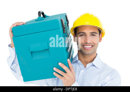 Smiling handyman in hard hat carrying a toolbox Stock Photo