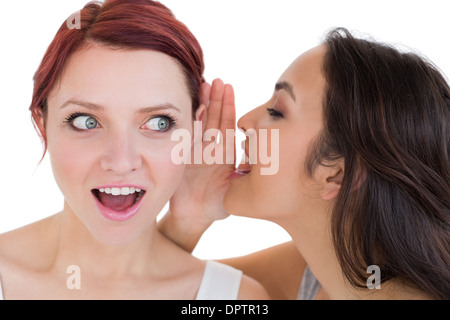 Close-up of two young female friends gossiping Stock Photo