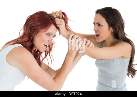 Angry young woman pulling females hair in a fight Stock Photo