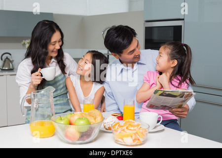 Family of four enjoying healthy breakfast in kitchen Stock Photo