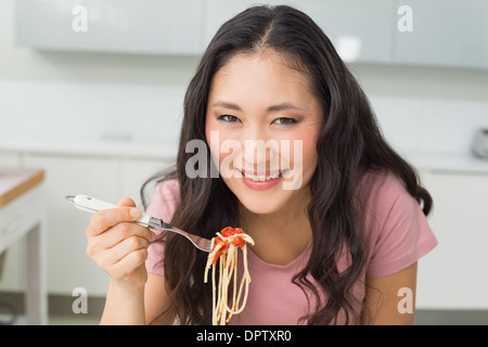 Portrait of a happy young woman enjoying spaghetti lunch Stock Photo