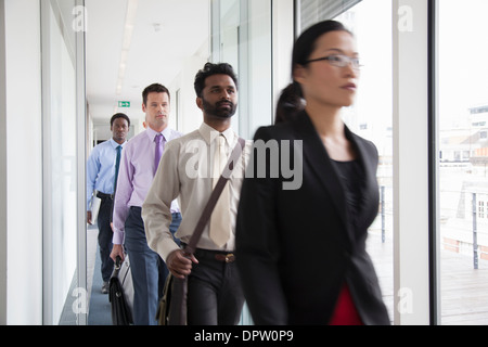 Office workers walking quickly down a corridor Stock Photo