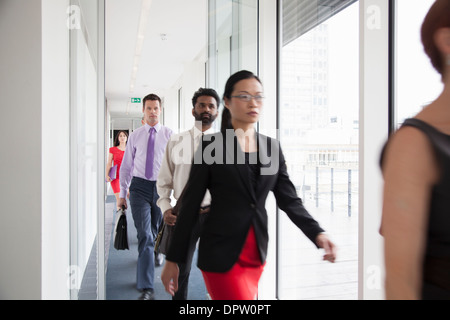 Office workers walking quickly down a corridor Stock Photo