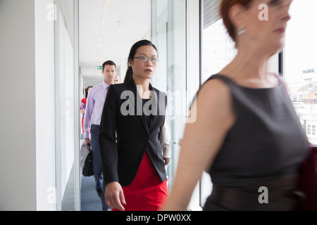 Office workers walking quickly down a corridor Stock Photo