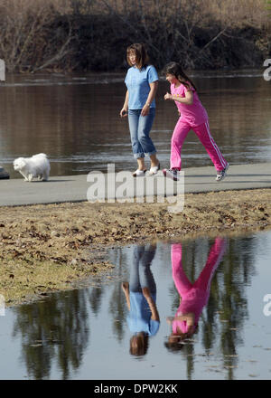 Sam Harrel/News-Miner.Eun Hee Alabran and her daughter Alicia take their dog Snowy for a walk on the bike path along the Chena River on Monday, May 4, 2009, near the Carlson Center. Water levels of the Chena and other local rivers peaked on Monday after a week of record-warm temperatures produced a massive snow melt. The rivers should begin dropping in the next day or two as things Stock Photo