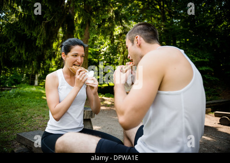 Young couple eating together after jogging outdoor in nature Stock Photo