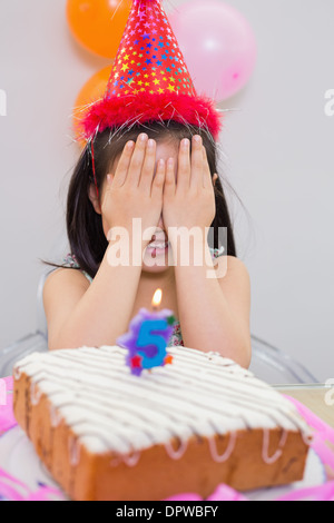 Girl covering her face at the birthday party Stock Photo