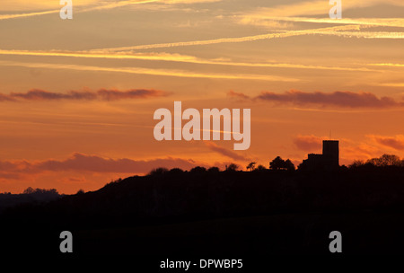 The sun sets behind the Church of St Mary and St Hardulph in Breedon on the Hill, Leicestershire Stock Photo