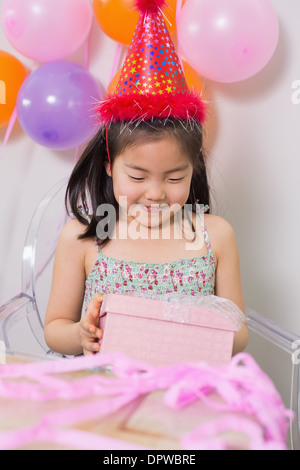 Little girl with gift box at her birthday party Stock Photo