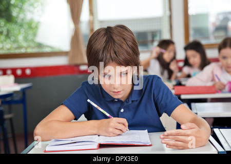 Schoolboy Cheating At Desk During Examination Stock Photo