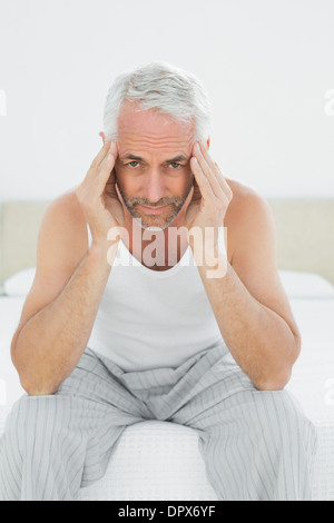 Mature man suffering from headache in bed Stock Photo