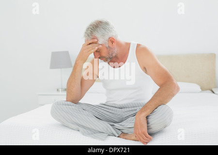 Mature man suffering from headache in bed Stock Photo