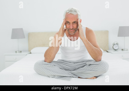 Mature man suffering from headache in bed Stock Photo