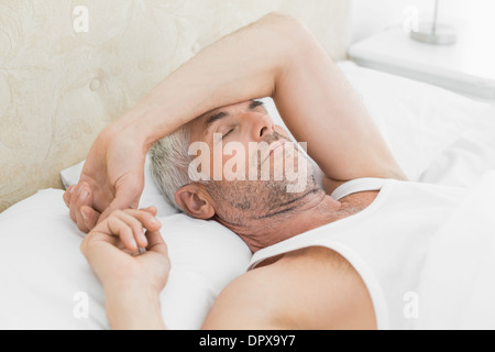 Mature man sleeping in bed at home Stock Photo