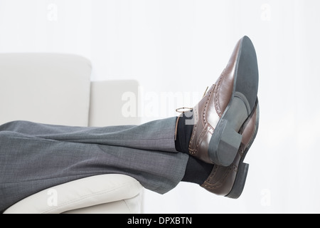 Low section side view of a businessman resting on sofa Stock Photo