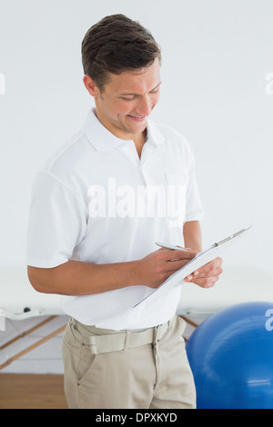 Trainer writing in clipboard at the gym hospital Stock Photo
