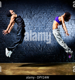 Young dancer couple jumping. On wall background. Stock Photo