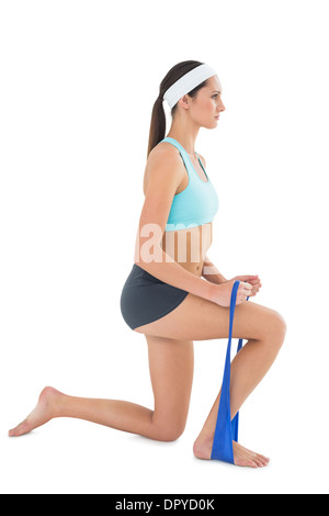 Fit young woman exercising with a blue yoga belt Stock Photo