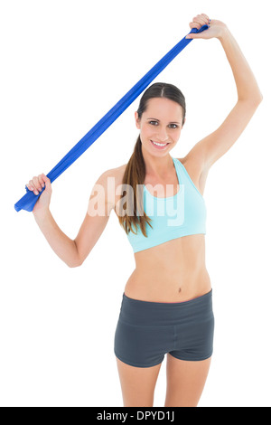 Smiling fit young woman holding blue yoga belt Stock Photo
