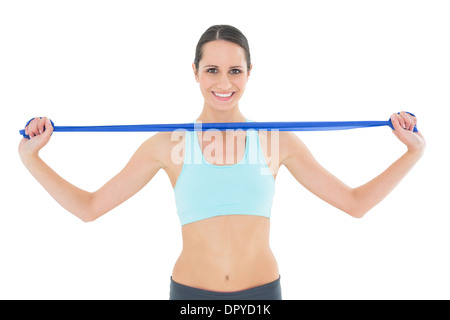 Smiling fit young woman holding blue yoga belt Stock Photo
