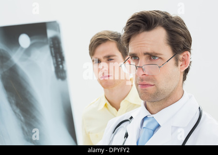 Concentrated male doctor and patient examining lungs x-ray Stock Photo