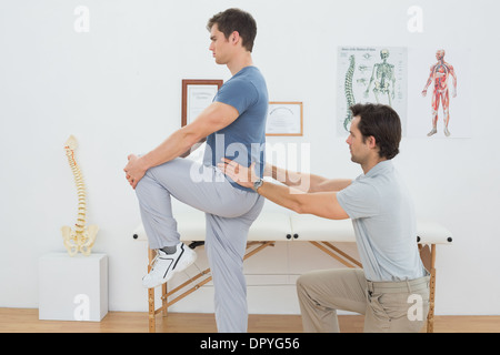 Side view of a male physiotherapist examining mans back Stock Photo