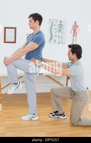 Side view of a male physiotherapist examining mans back Stock Photo