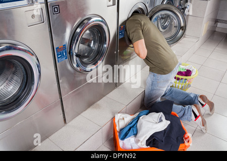 Man Searching Clothes Inside Washing Machine Stock Photo