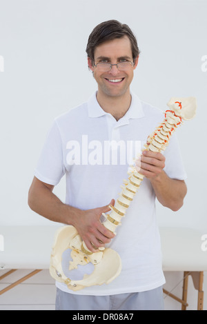 Portrait of a smiling doctor holding skeleton model Stock Photo