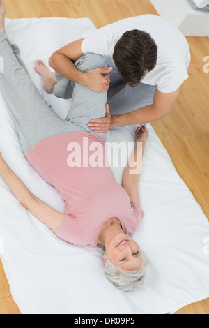 Physical therapist examining senior woman's leg Stock Photo