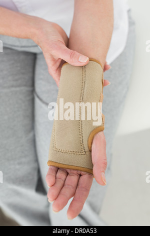 Close-up mid section of a woman with hand in wrist brace Stock Photo