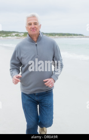Portrait of a senior man running at beach Stock Photo