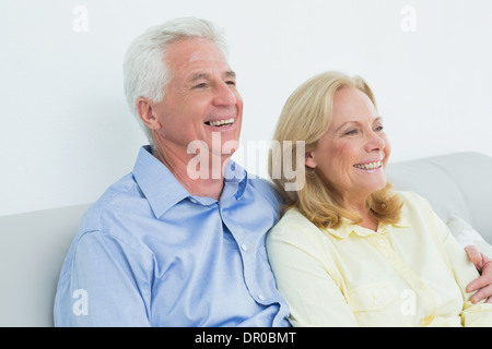 Relaxed loving senior couple sitting on sofa Stock Photo