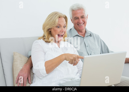 Cheerful senior couple using laptop at house Stock Photo