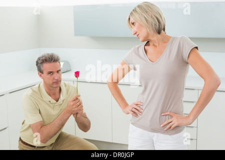 Man making a proposal to woman in kitchen Stock Photo