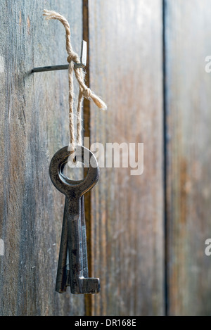 old keys tied with string and hanging from a spike Stock Photo