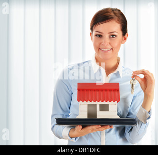 Young woman holding small house and keys Stock Photo - Alamy