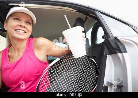 Caucasian tennis player climbing out of car Stock Photo