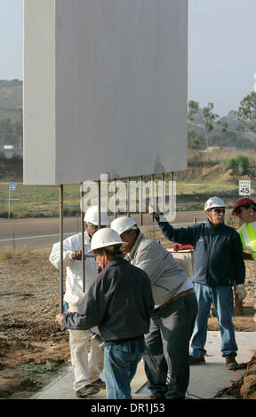 December 4, 2008, Oceanside, California, USA Workers install steel coil rods into the bottom of this section of the Mission San Luis Rey's new 12 foot tall concrete sign that's about to be lowered on to its base. The rods will go into grout filled holes drilled into the base they are standing on. Another panel of the same shape, but with writing facing the opposite direction, will  Stock Photo
