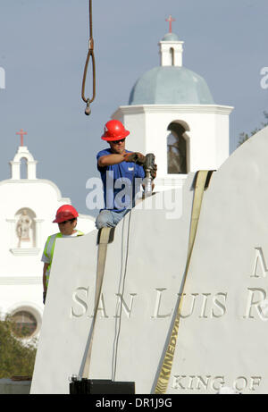 December 4, 2008, Oceanside, California, USA SHANNON JARRETT, right, installs an anchor bolt into the top of this section of the Mission San Luis Rey's new concrete 12 foot tall sign. The bolts are to be used to attach cables to them so a crane can lift it up and place it on the sign's base. The Mission's bell tower can be seen in the background Credit: photo by Charlie Neuman, San Stock Photo
