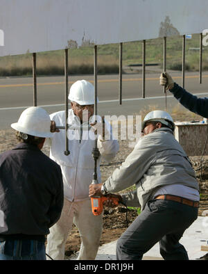 December 4, 2008, Oceanside, California, USA WorkersALEX JOHNSON, left, white jacket, and JUSTO ALVAREZ, and others install steel coil rods into the bottom of this section of the Mission San Luis Rey's new 12 foot tall concrete sign that's about to be lowered on to its base. The rods will go into grout filled holes drilled into the base they are standing on. Another panel of the sa Stock Photo