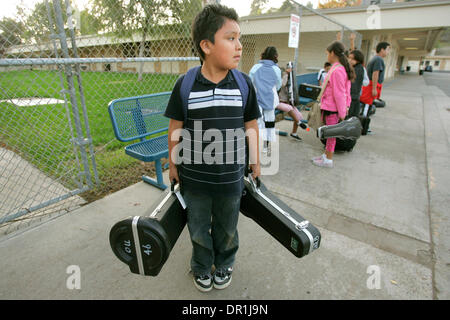 December 4, 2008, Oceanside, California, USA Garrison Elementary School fifth grader DAVID AMBROCIO carries a trombone and violin, both instruments he's learning to play in teacher Steven Traugh's orchestra class. Here the class just ended and he's waiting for his Ballet Folklorico class to begin in the school's cafeteria Credit: photo by Charlie Neuman, San Diego Union-Tribune/Zum Stock Photo