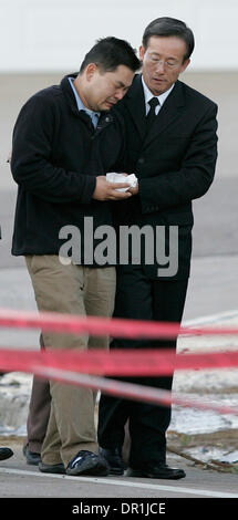 December 09, 2008. San Diego,  CA. - DONG YUN YOON (LEFT) arrived at the site of Monday's Marine Corps F/A-18D crash with his minister THE REV. DANIEL SHIN (right) as well as friends and representatives from the San Diego Police Department (not shown). Husband and father DONG YUN YOON was visiting the remains of his University City home, the day after a military F/A-18D crashed int Stock Photo