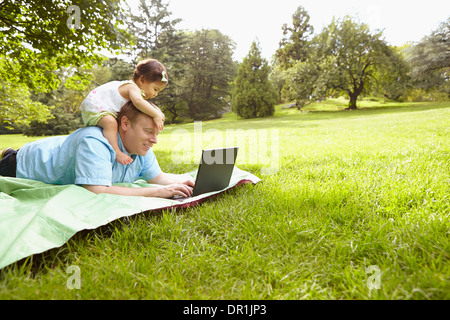 Father and baby girl using laptop in park Stock Photo