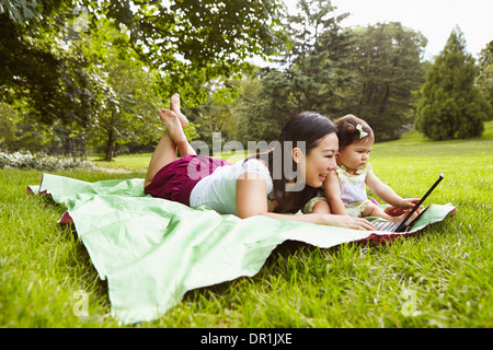 Mother and baby girl using laptop in park Stock Photo