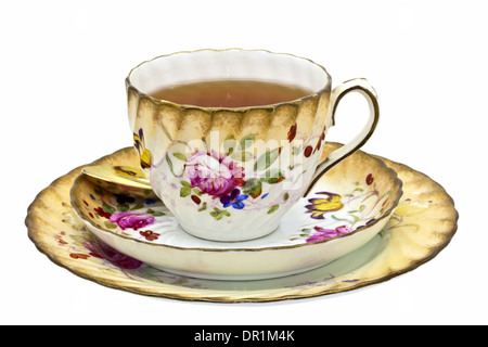 Tea in an antique china cup with saucer and dessert plate. Stock Photo